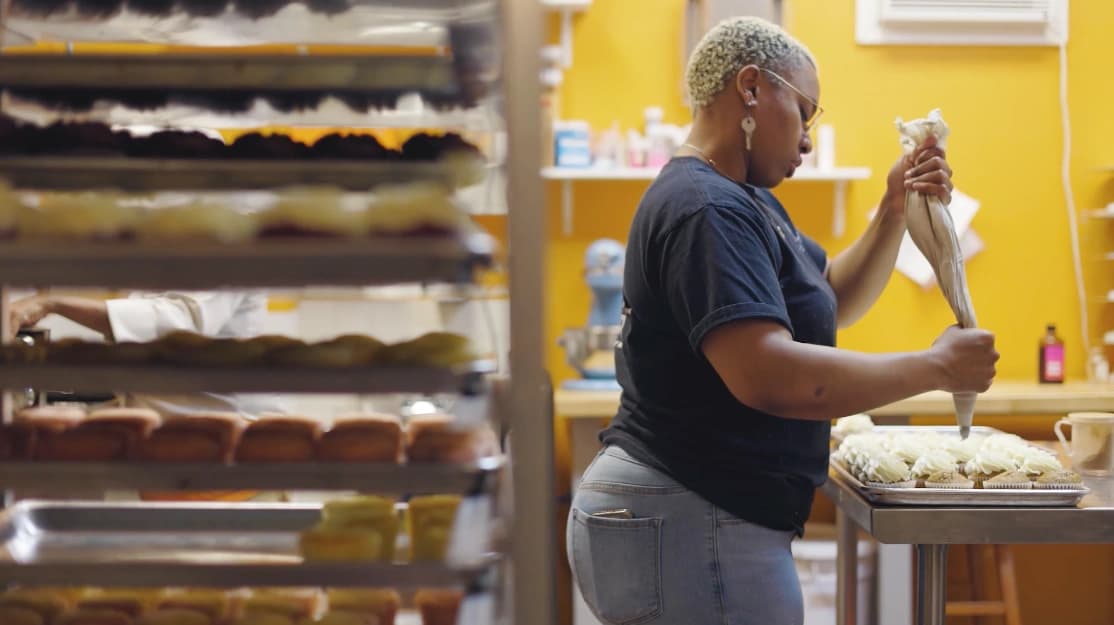 Video thumbnail of woman icing cupcakes in a bakery. Video thumbnail of woman icing cupcakes in a bakery.